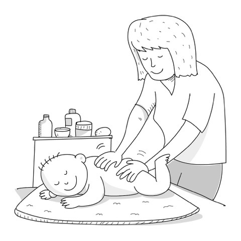 Una mamma massaggia la schiena al figlio neonato sul fasciatoio